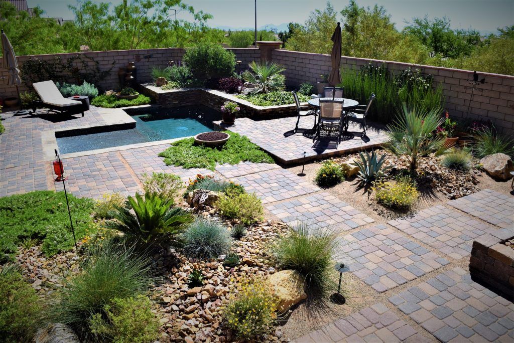 A backyard with a pool and patio area. A backyard with a pool and patio area.
